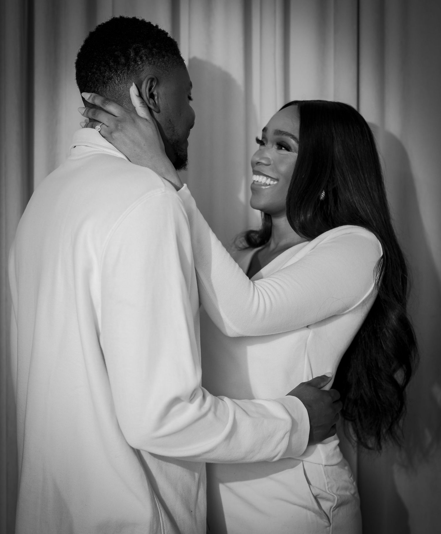 Black and white engagement photo of a couple embracing romantically
