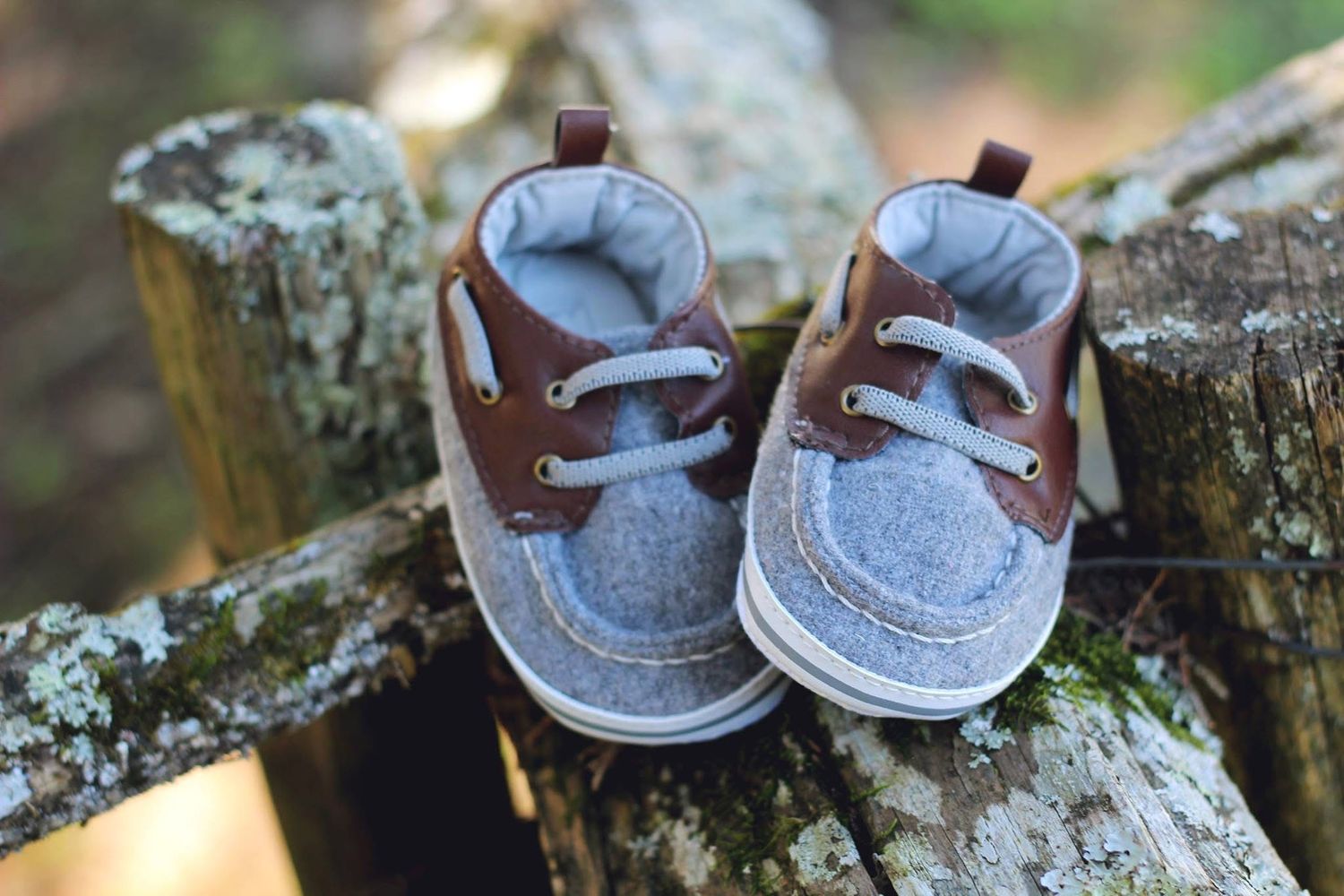 A photograph by Sara Pang (MSK Productions) of baby shoes on a wooden fence taken in Midwest, USA.