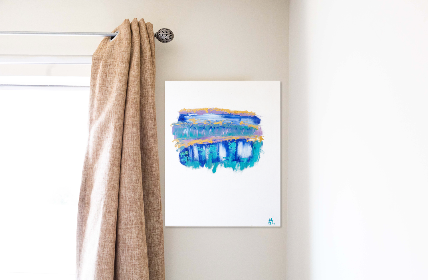 An abstract painting by Sara Pang with blue, gold, and green on the canvas hanging on the wall beside burlap curtains.