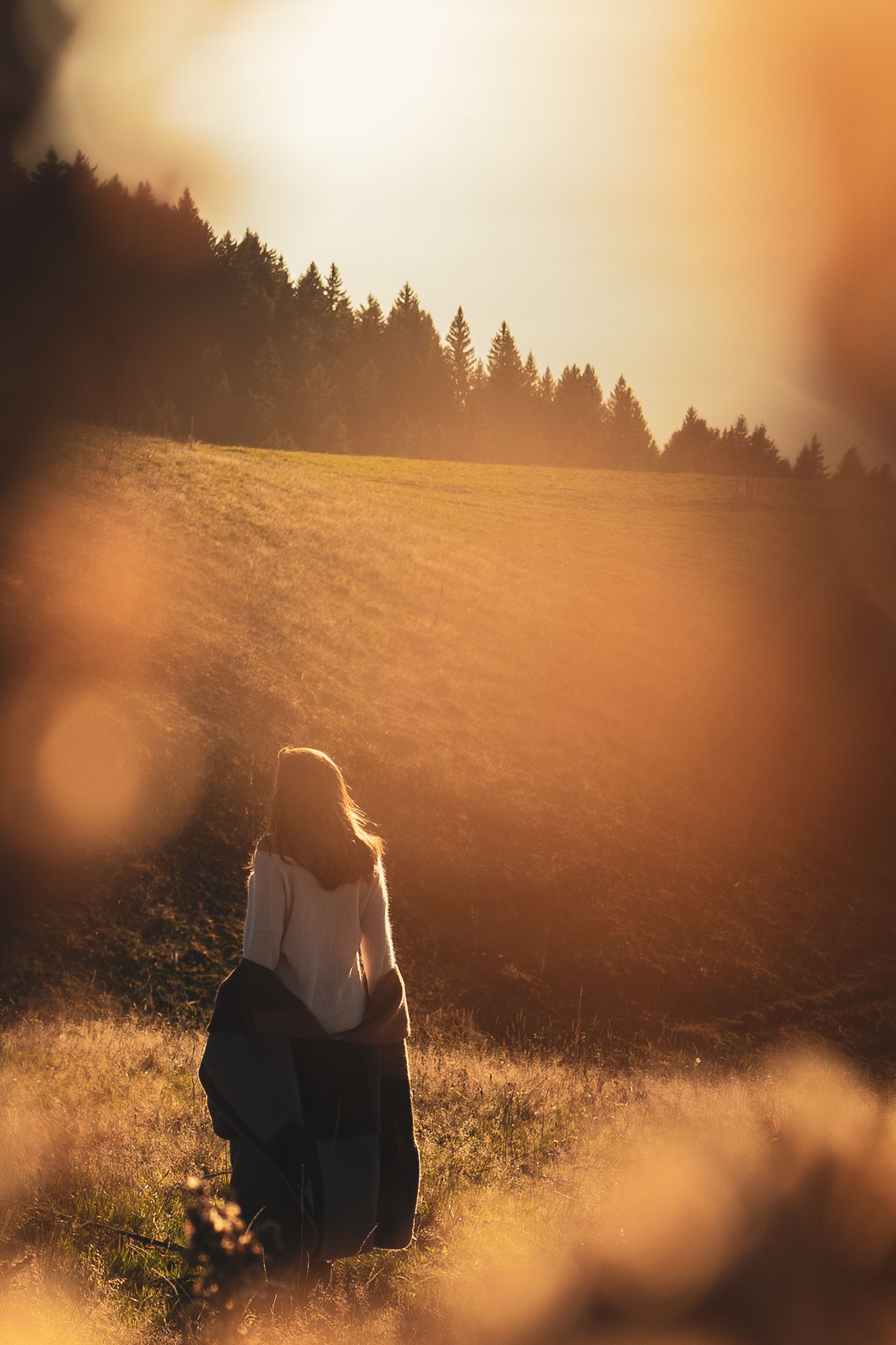Une femme qui marche en montagne au coucher du soleil à Annecy.