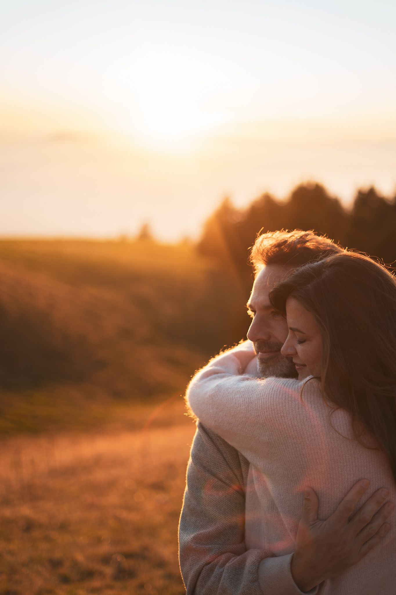 Un couple amoureux qui s'enlace au coucher du soleil en montagne à Annecy.