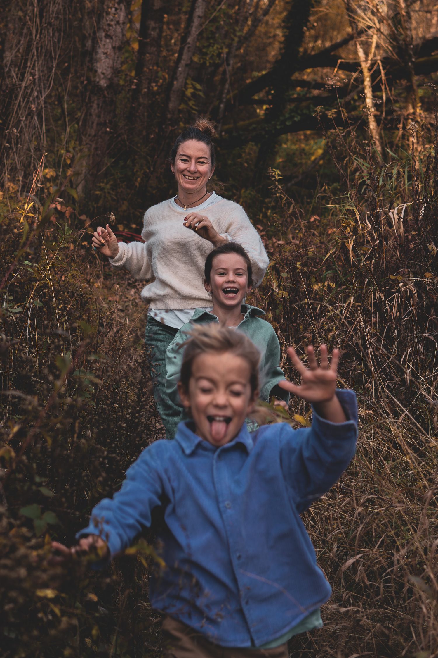 Maman et ses enfants courent en forêt près d'Annecy en automne