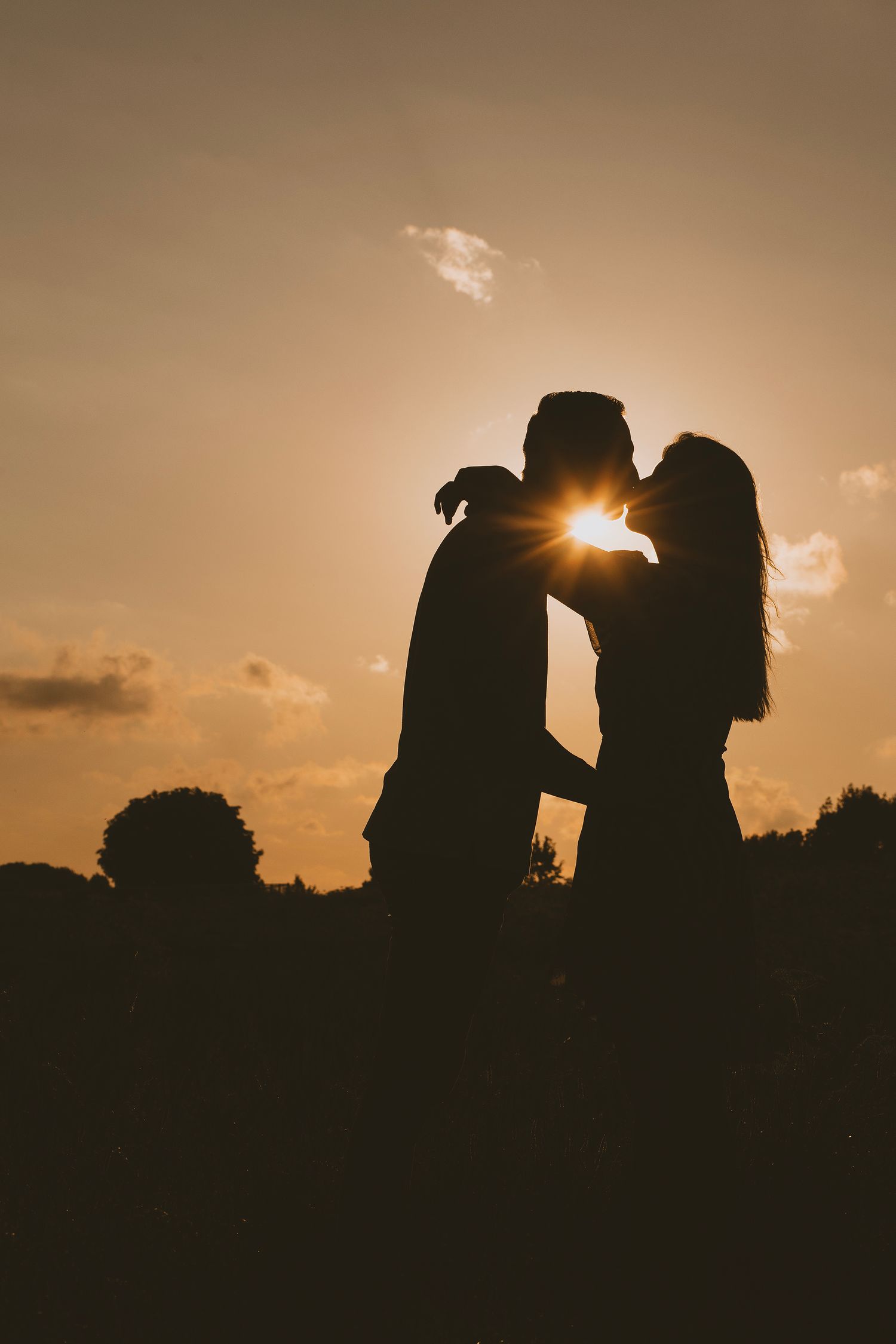 Silhouette van een stel tijdens zonsondergang. Voorbeeld van een pre-weddingshoot.