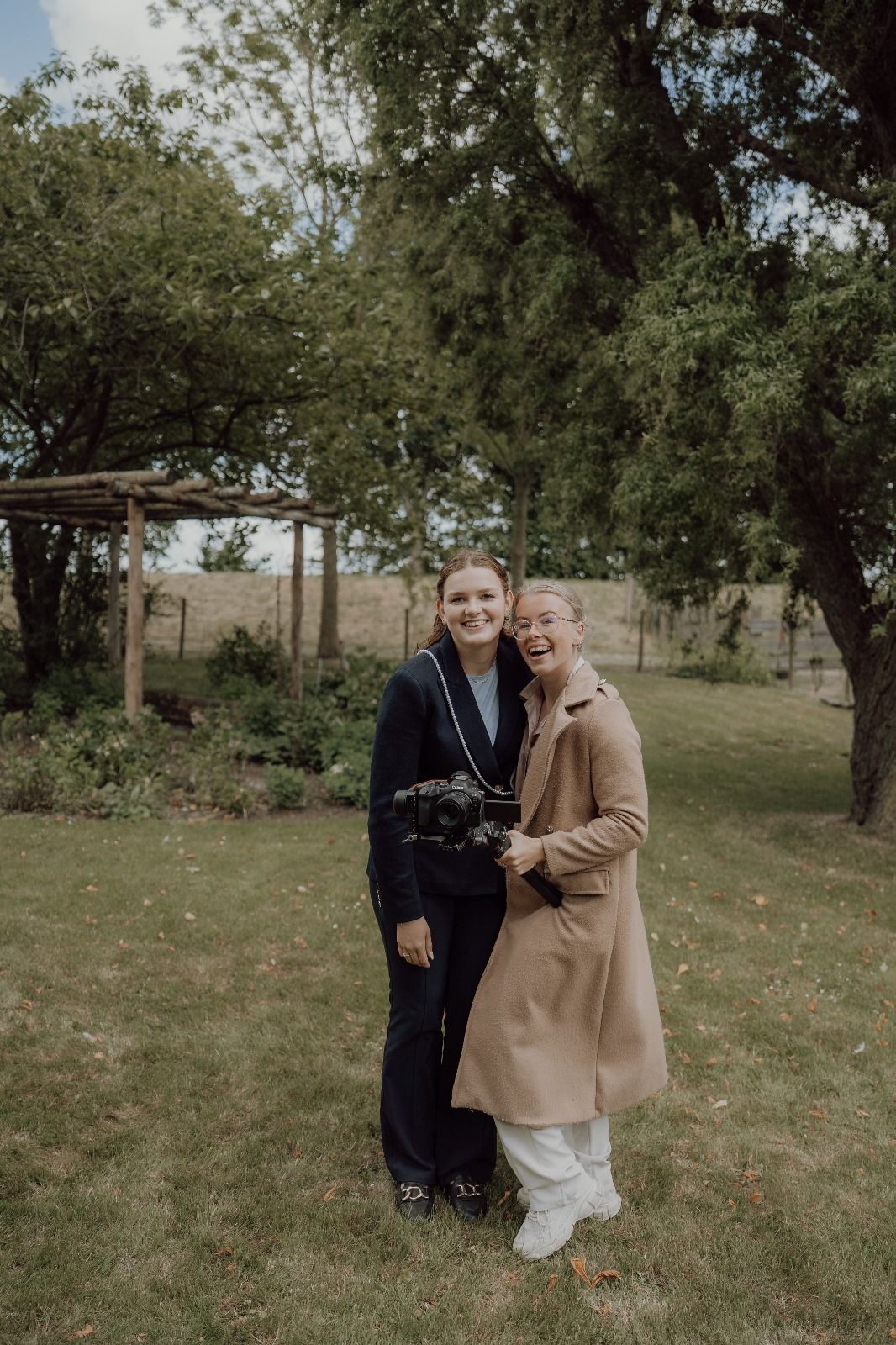 A couple shares a joyful embrace in a garden setting during golden hour.
