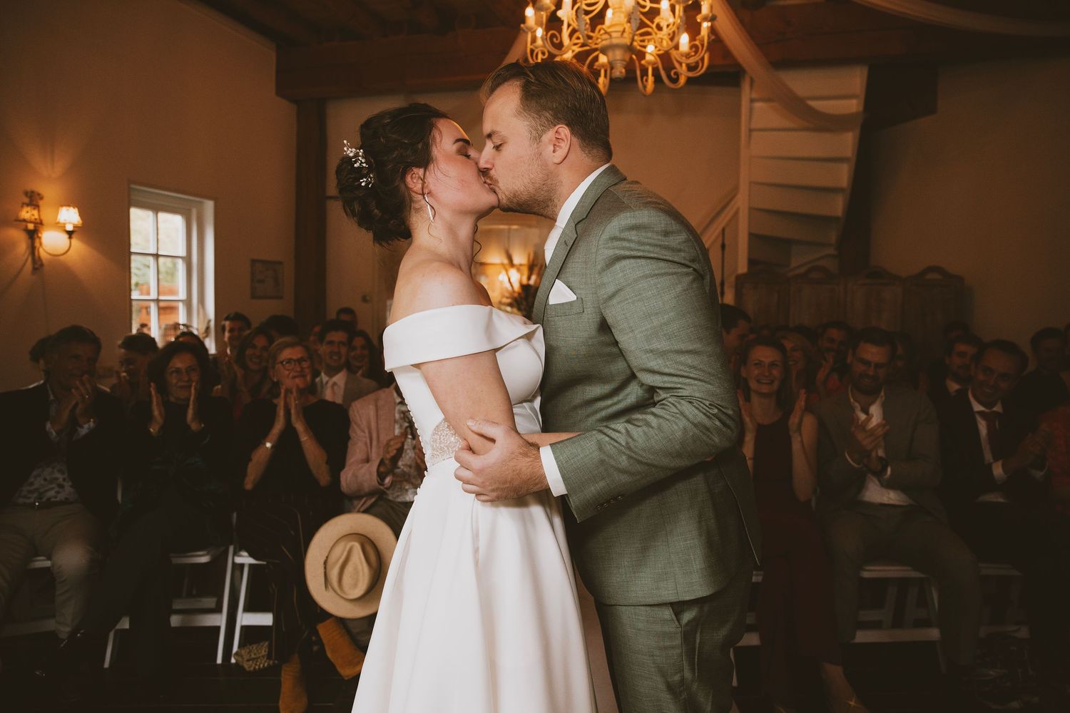 Newlyweds share an intimate moment during their first dance in a warmly lit reception venue.