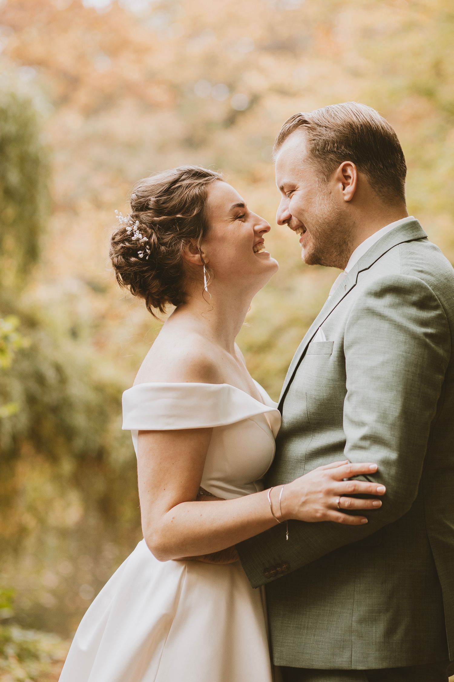 A couple shares an intimate moment together during their autumn wedding photoshoot in a park.