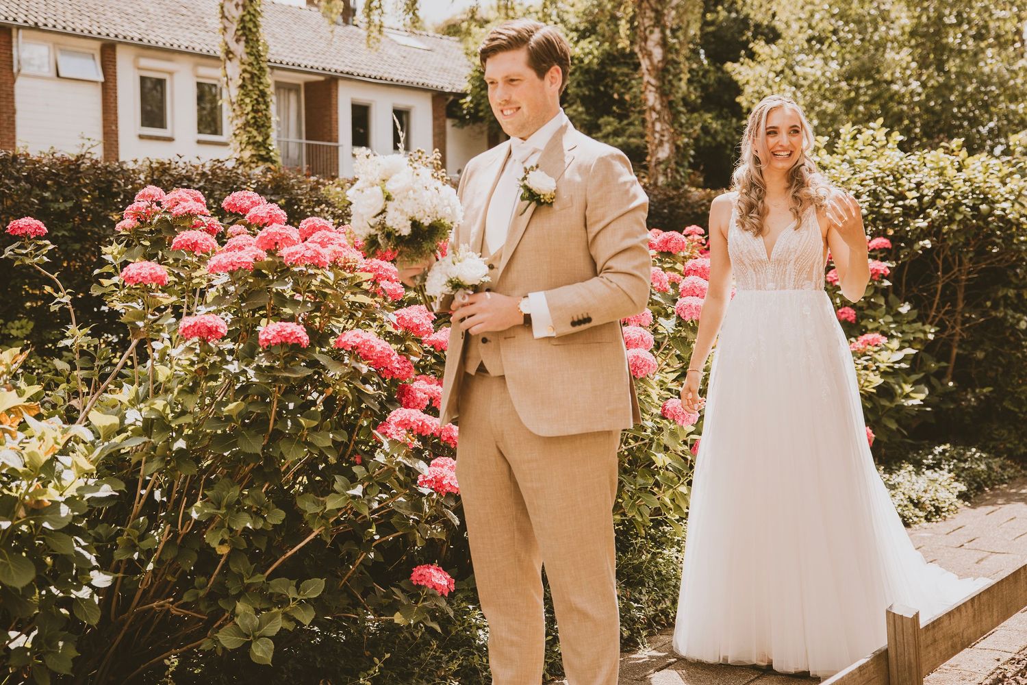 First look van de bruid en bruidegom in de voortuin.
