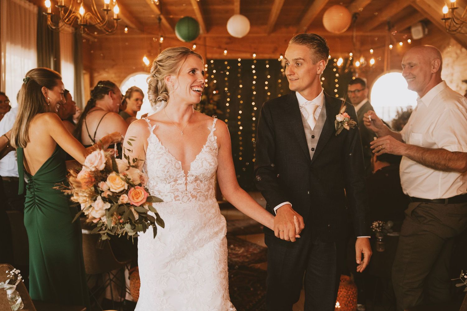 Wedding reception dance party with string lights and paper lanterns creating a warm, festive atmosphere.