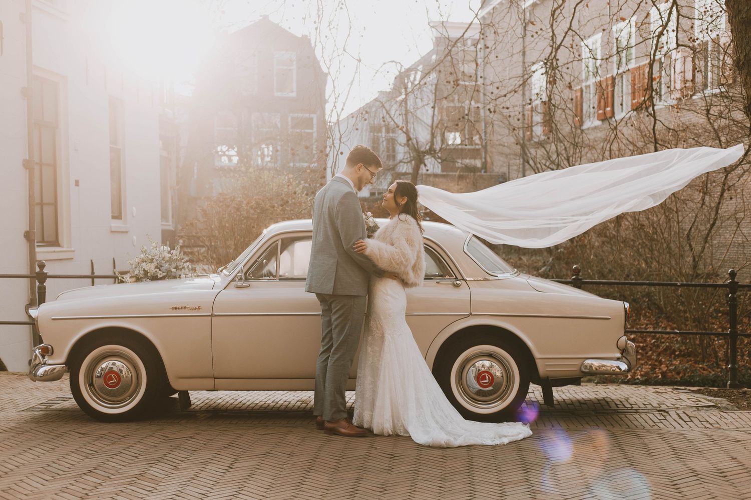 A series of five vintage-style wedding photographs showing a couple in romantic poses with classic cars and outdoor settings.