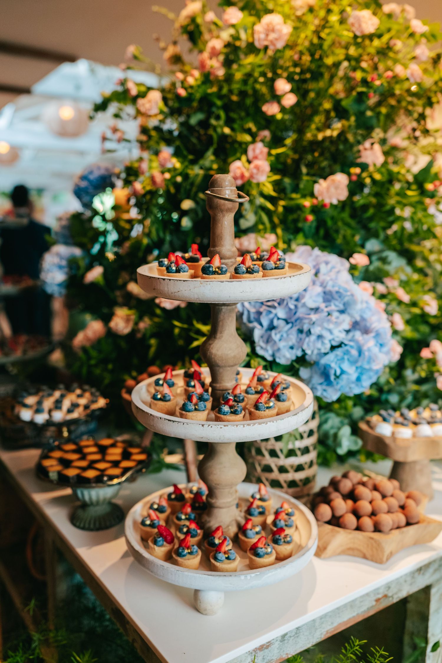 Botanical wedding details at Botânico Quintal featuring blue hydrangeas and Brazilian sweets.