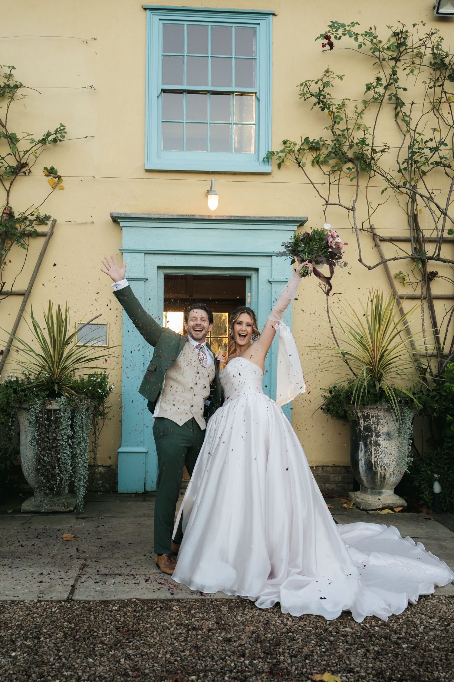 “Bride and groom celebrating under falling confetti, joyful wedding moment at South Farm Royston, captured by a UK London wedding photograph