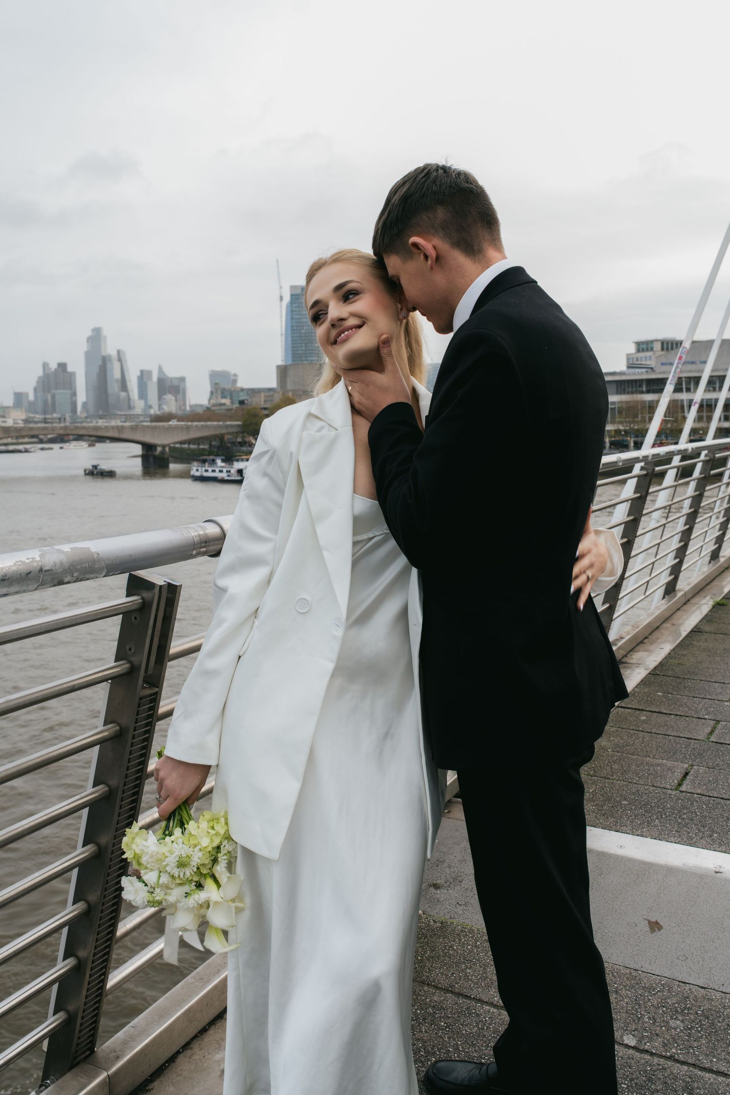“Couple on Hungerford Bridge with London skyline views during a Central London photoshoot.”