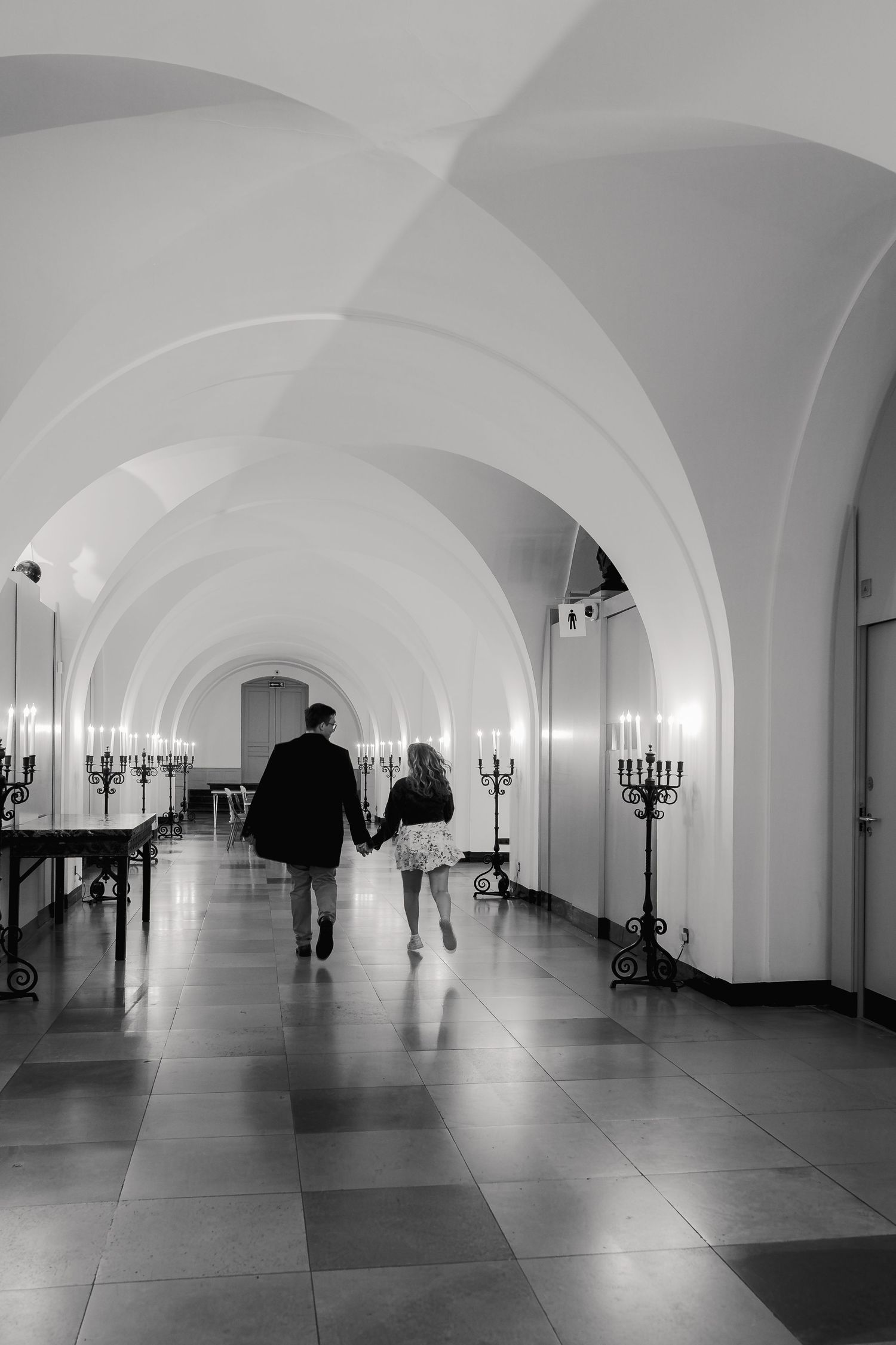 Candid engaged couple walking through Banqueting House London after proposal