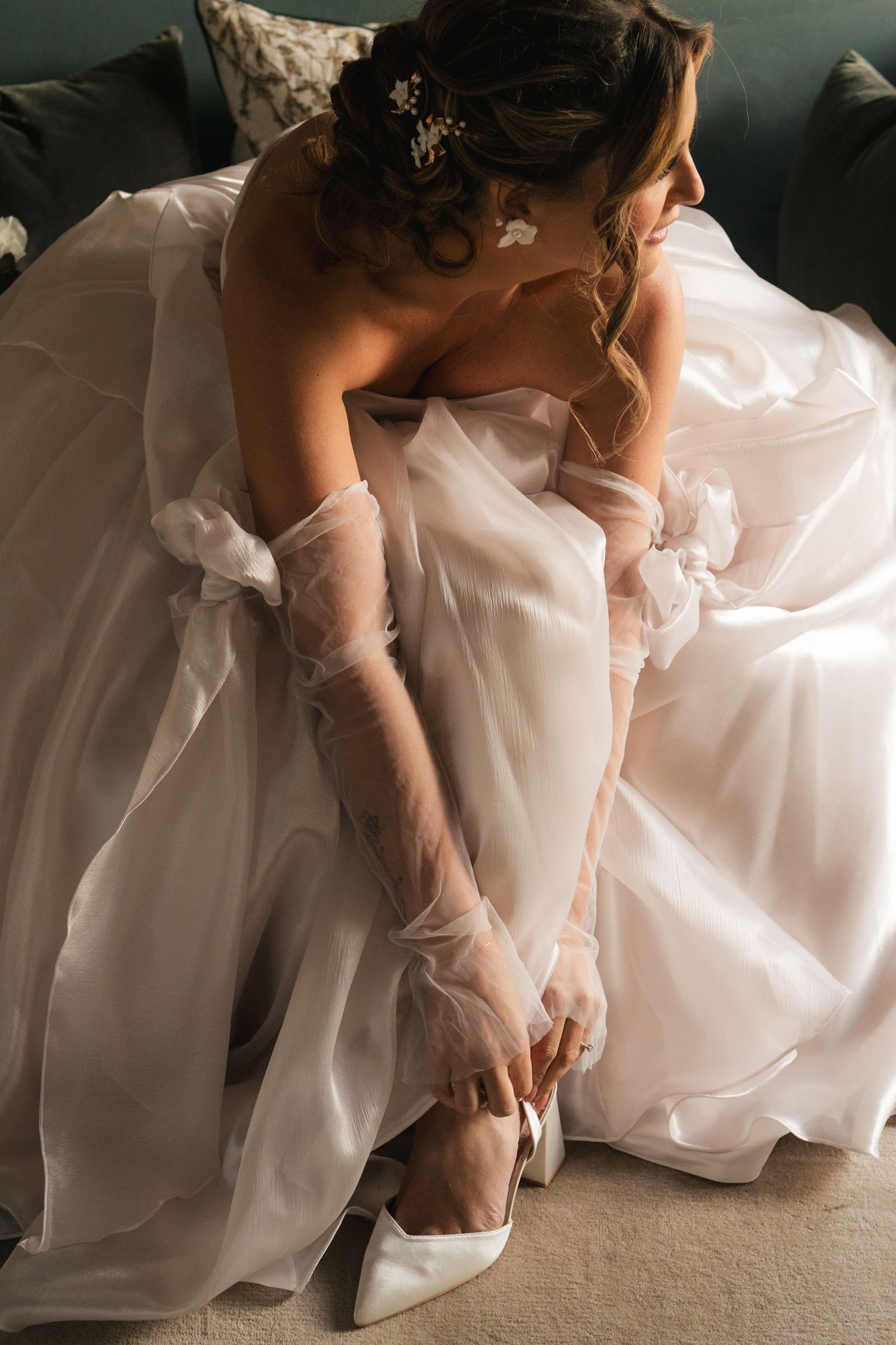 Bride adjusting her shoes during getting-ready moments at South Farm Royston, captured by a UK London wedding photographer. @lyfphotos