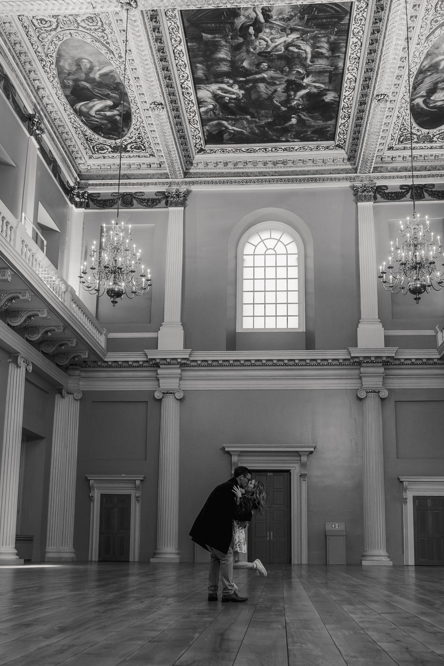 Candid engaged couple walking through Banqueting House London after proposal