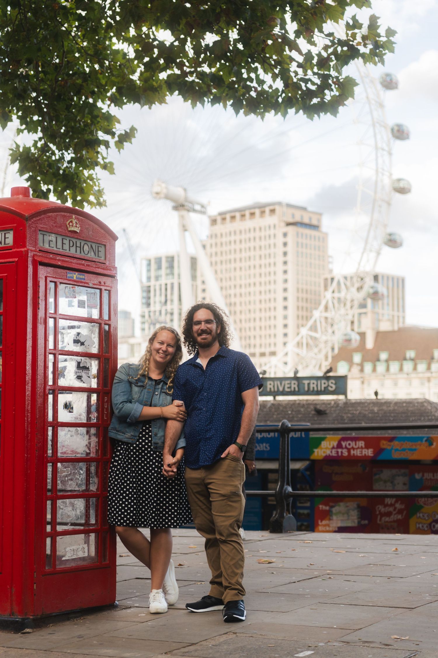 Couple posing next to a red phone booth near the London Eye on the South Bank captured by UK Photographer @lyfphotos