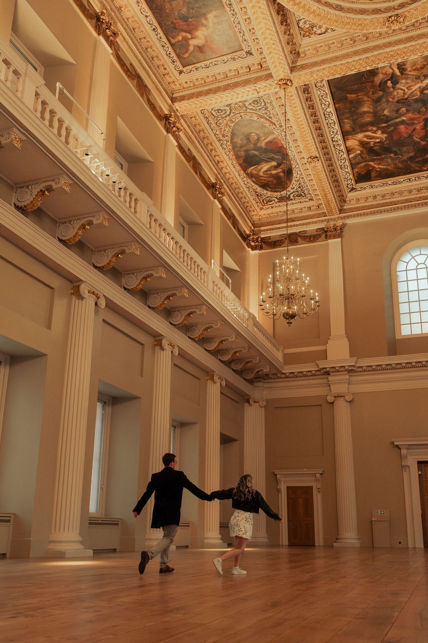 Candid engaged couple walking through Banqueting House London after proposal