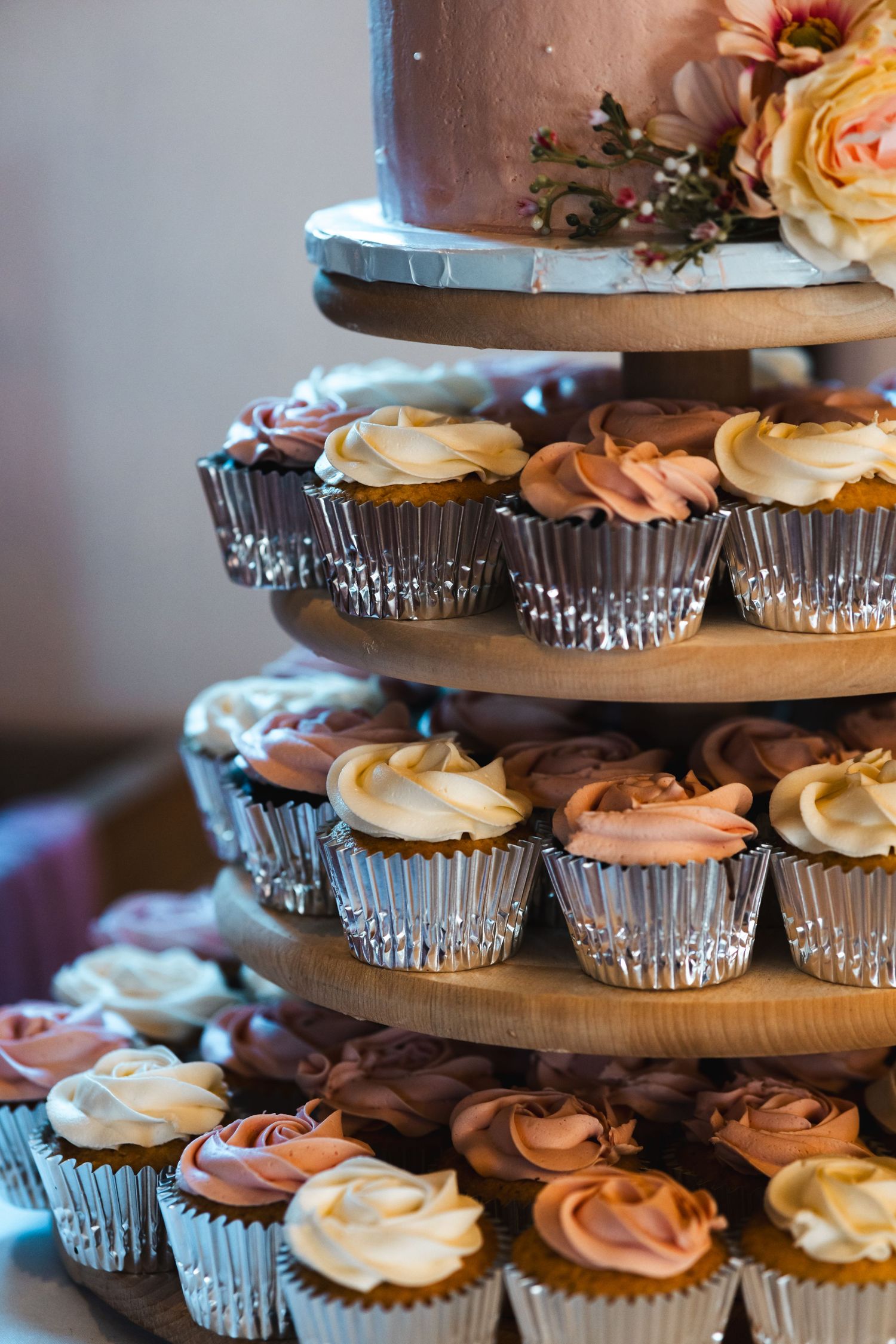 Wedding dessert table with a tiered cupcake display at The Tithe Barn Bedford, captured by a UK London wedding photographer.