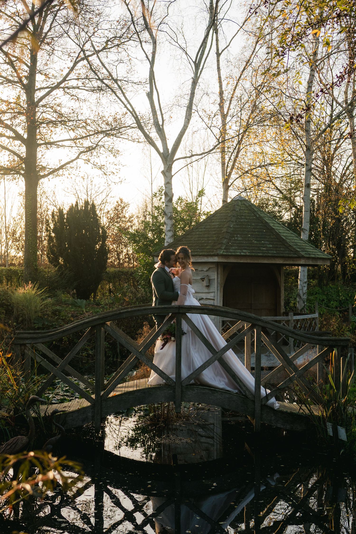 “Couple sharing a romantic moment on the bridge at South Farm Royston, captured by a UK London wedding photographer.”