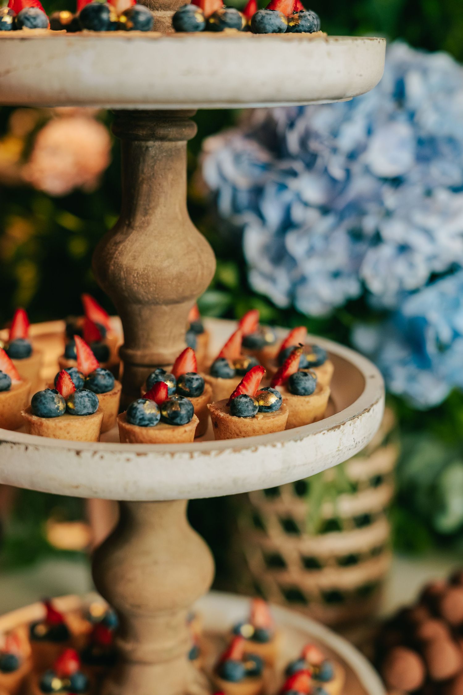 Botanical wedding details at Botânico Quintal featuring blue hydrangeas and Brazilian sweets.