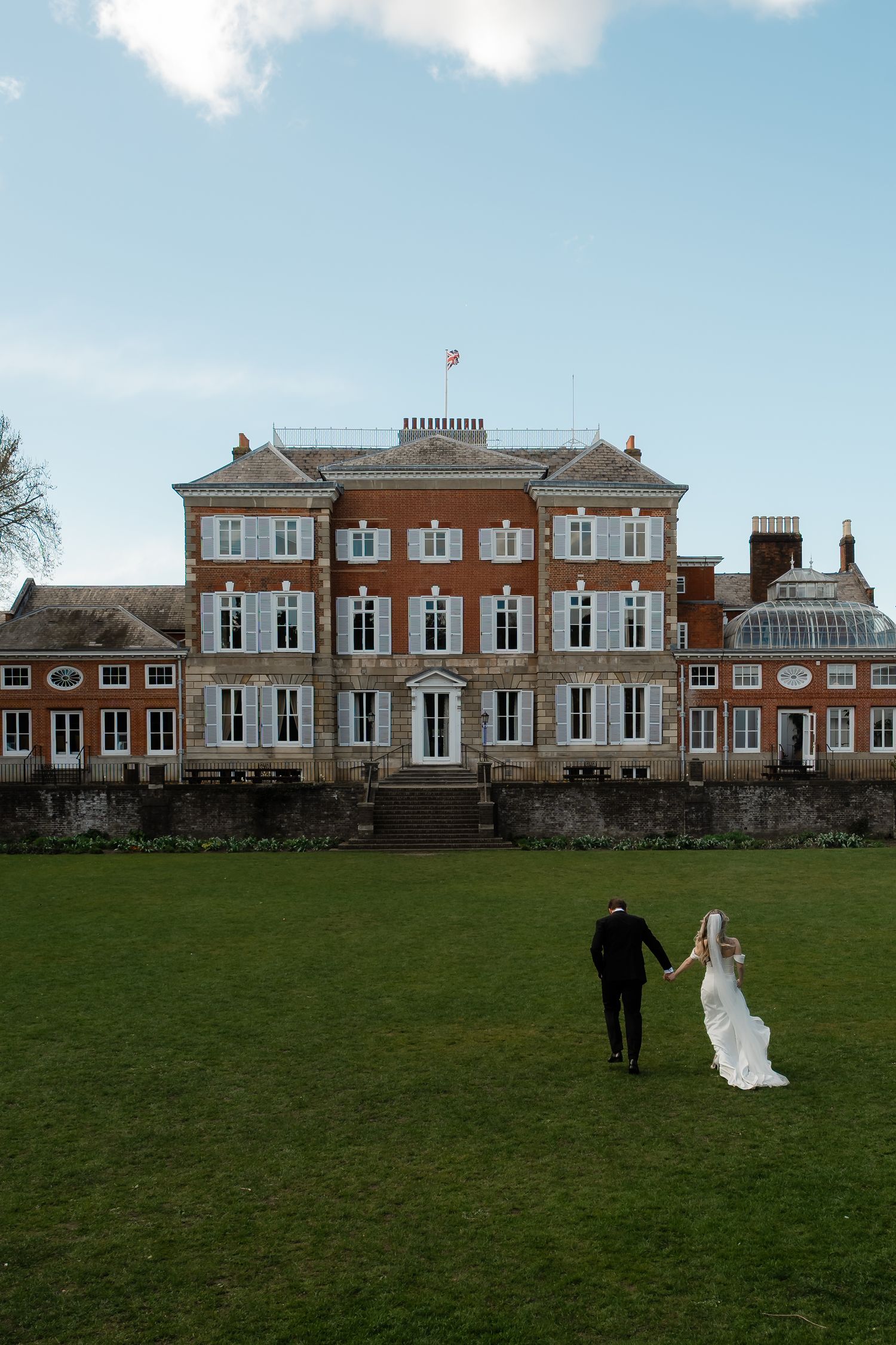 Bride and groom walking through York House gardens in spring