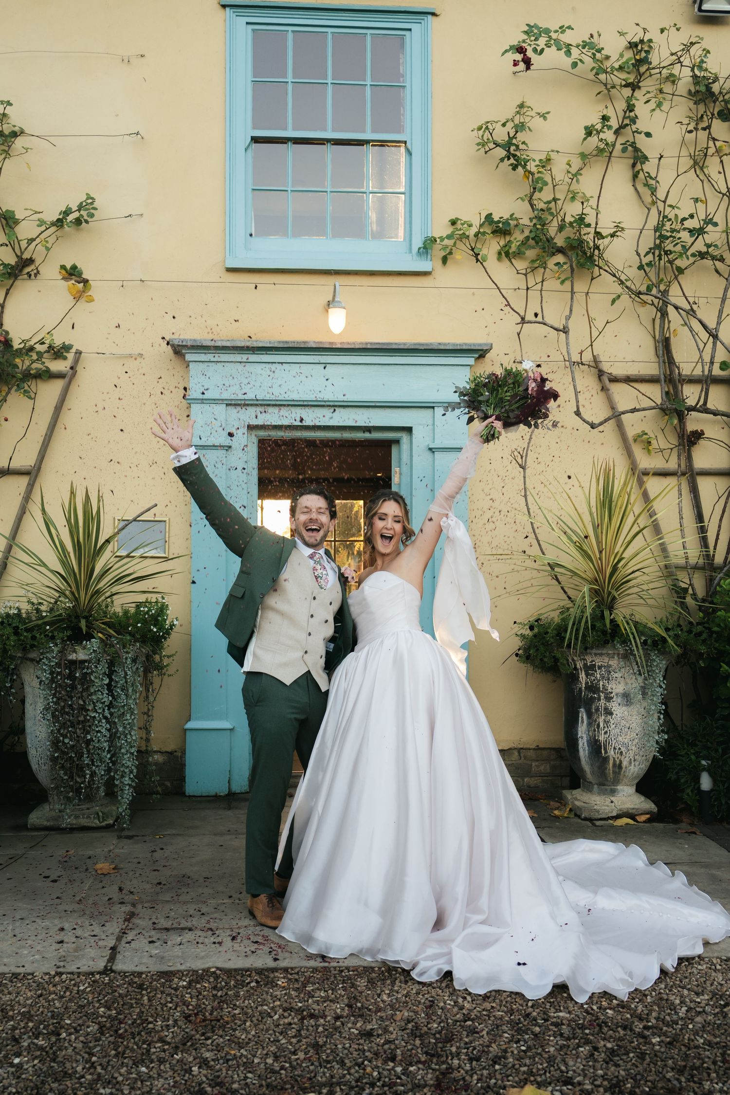 “Bride and groom celebrating under falling confetti, joyful wedding moment at South Farm Royston, captured by a UK London wedding photograph