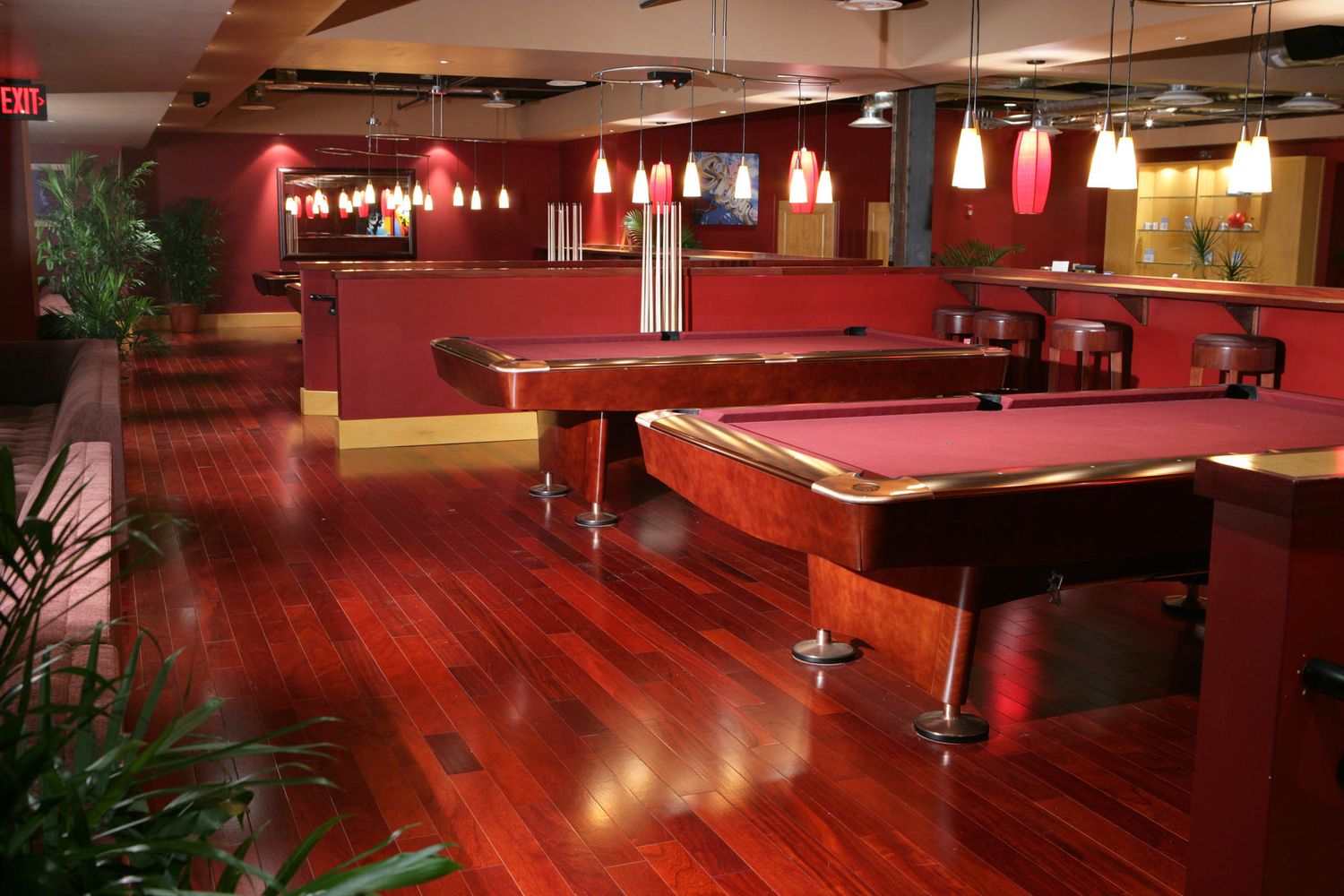 Modern bowling alley featuring red accents, mood lighting, and multiple lanes.