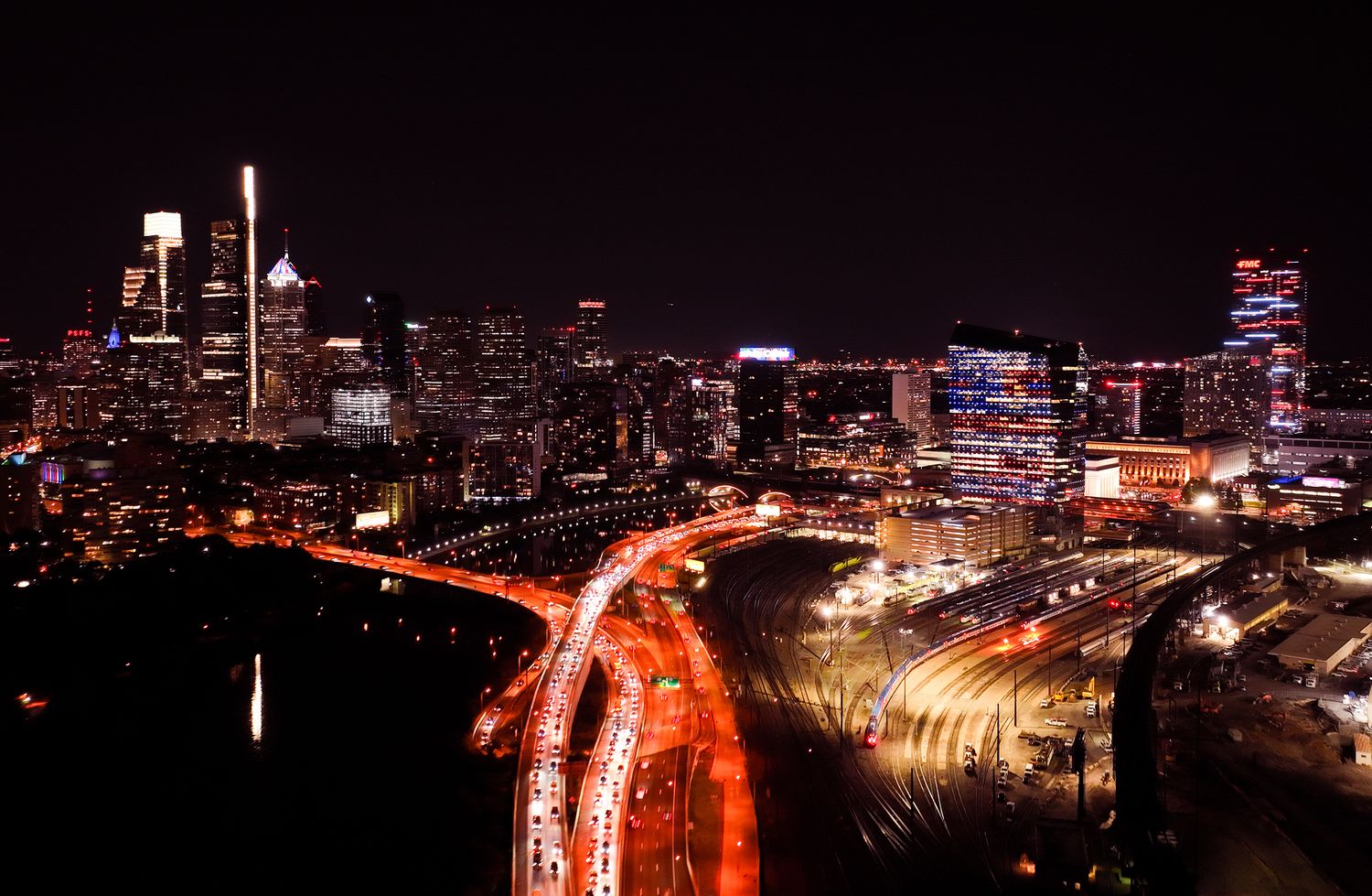 Night panorama of city highways with glowing red light trails from traffic.