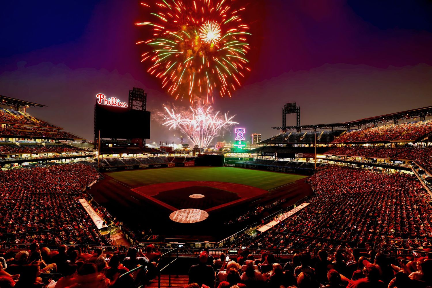 Fireworks display over a baseball stadium during a nighttime celebration.