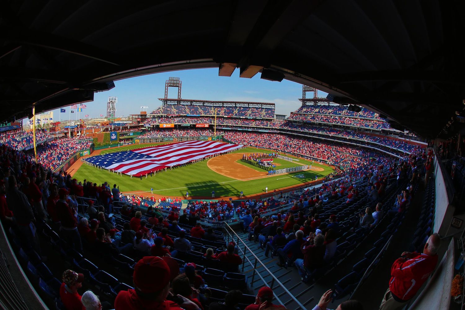 Wide angle view of a baseball stadium during a game with crowded stands.