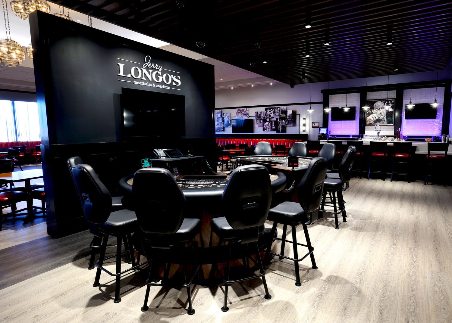 Modern sports bar interior with multiple screens and sleek black furniture.
