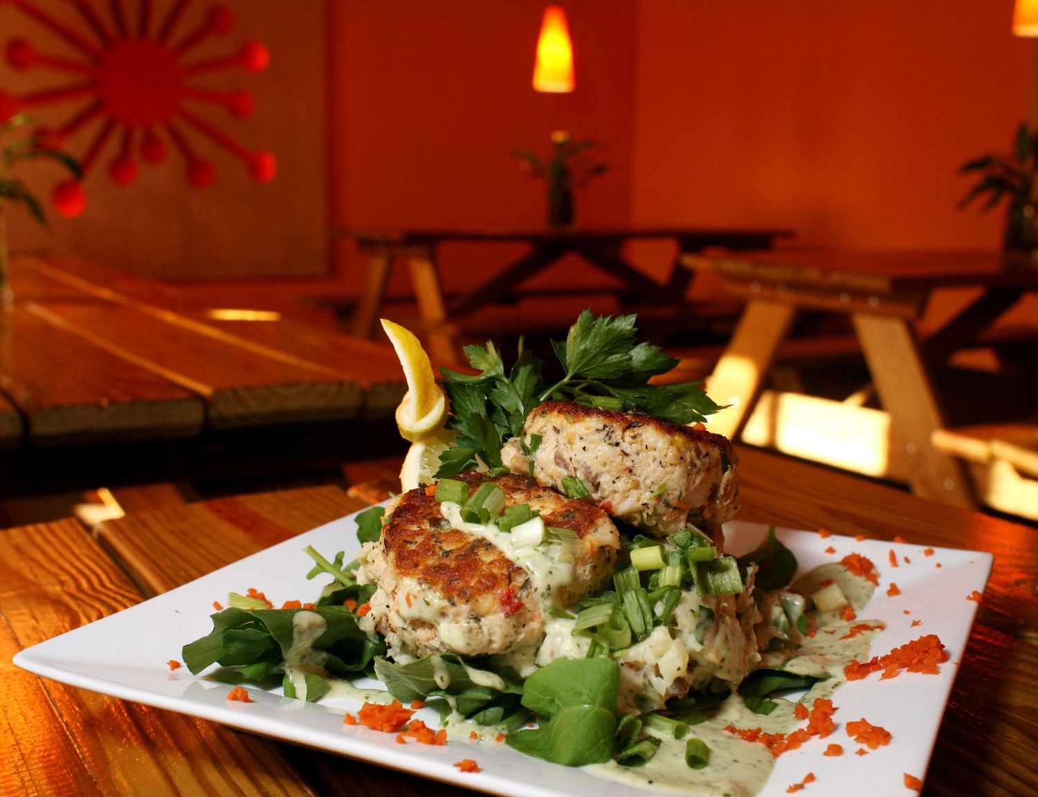 Artfully plated dishes with garnish under warm lighting in an upscale restaurant setting.