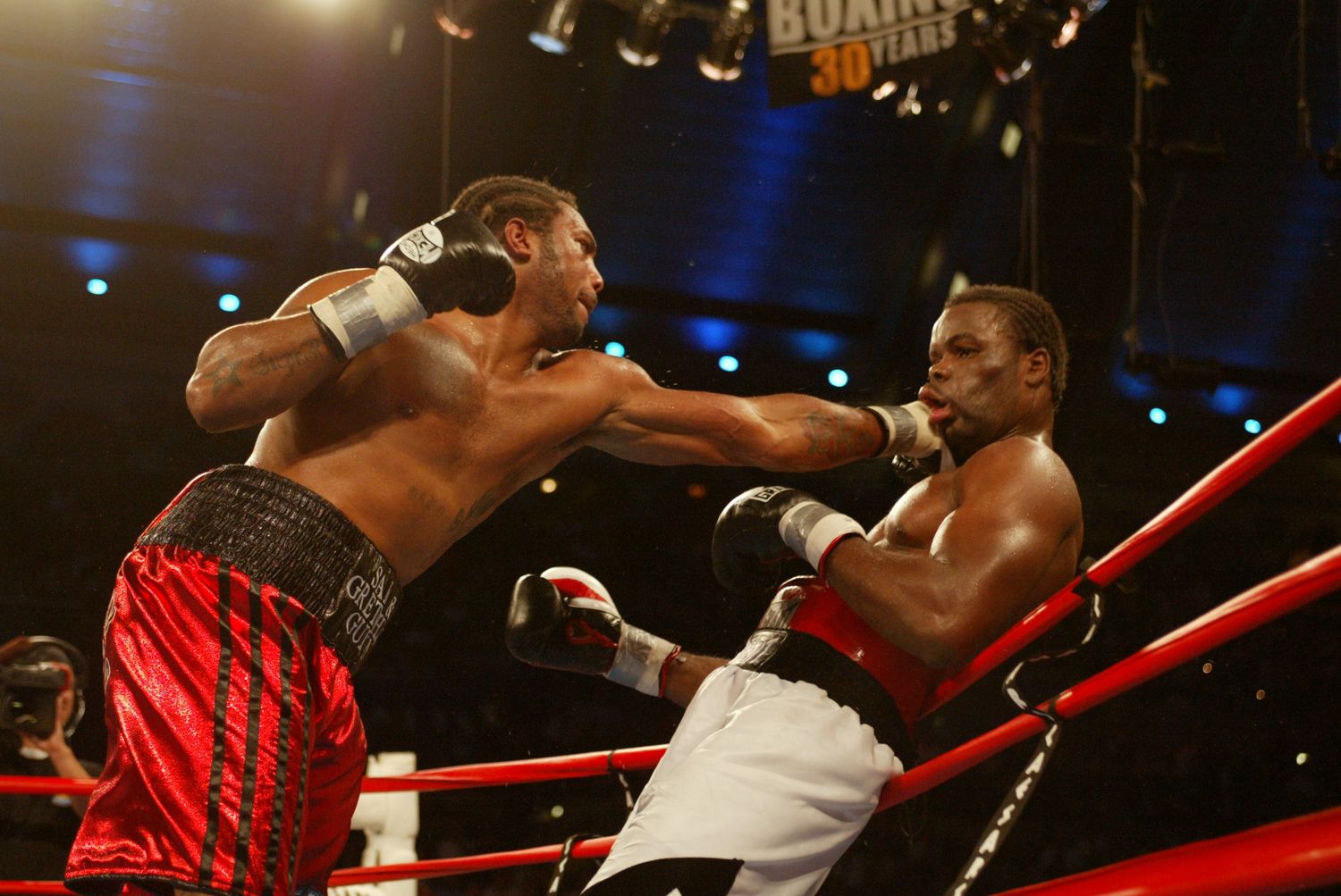 Professional boxers trading powerful punches during an intense fight.