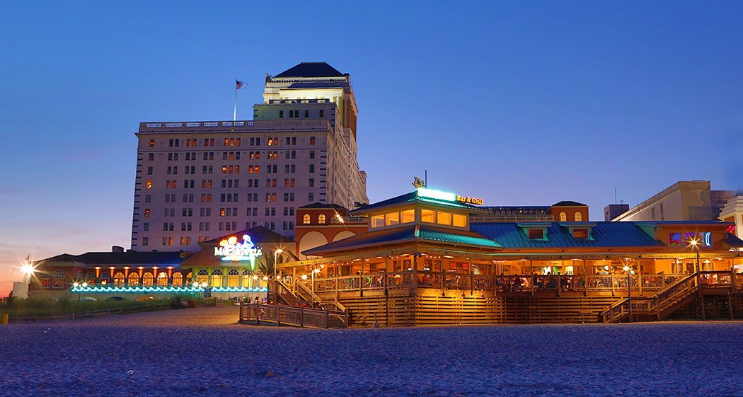 Panoramic view of casino hotels along the Atlantic City boardwalk at dusk.