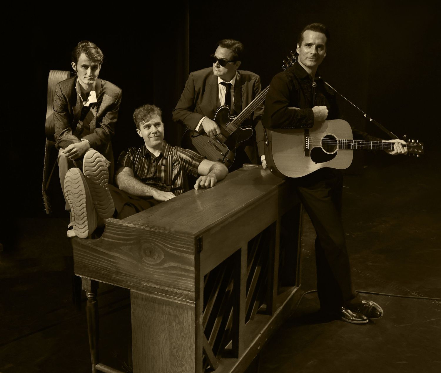 Vintage style photo of music group posed with instruments in black and white.