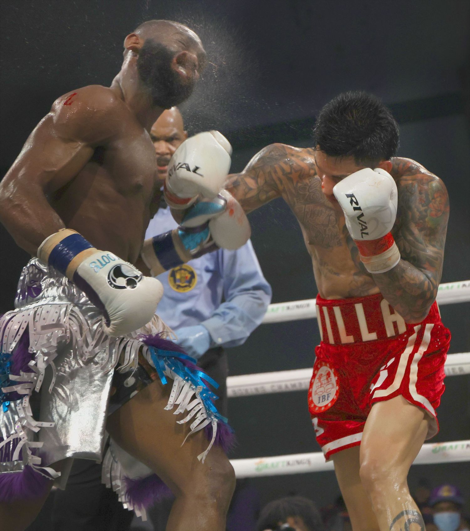 Two boxers exchange powerful punches during an intense boxing match.