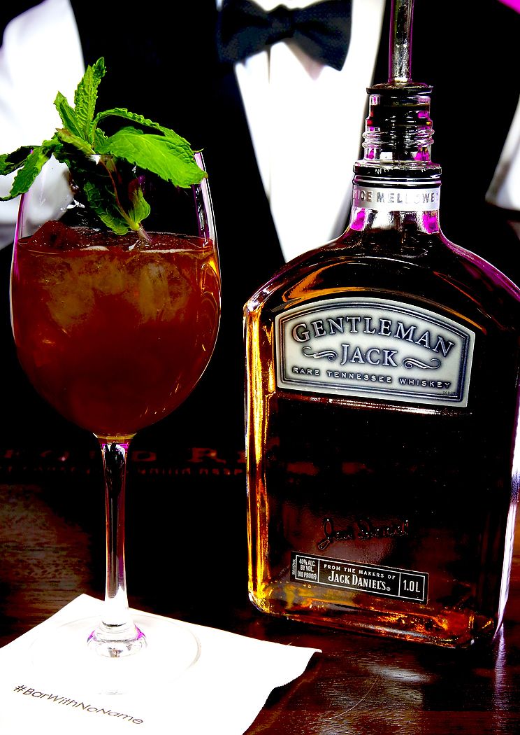 Jack Daniel's Gentleman Jack whiskey bottle displayed with cocktail glass.