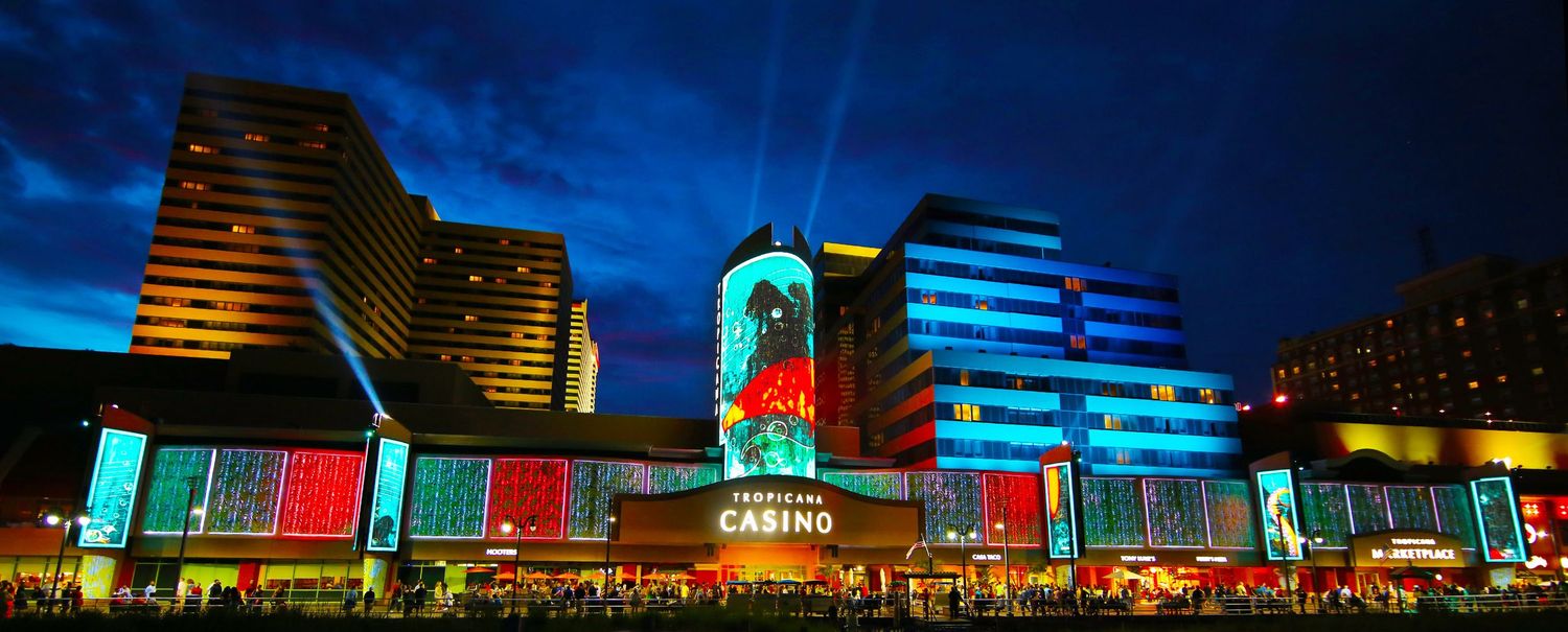 Urban skyline with neon-lit buildings and colorful architectural lighting at night.
