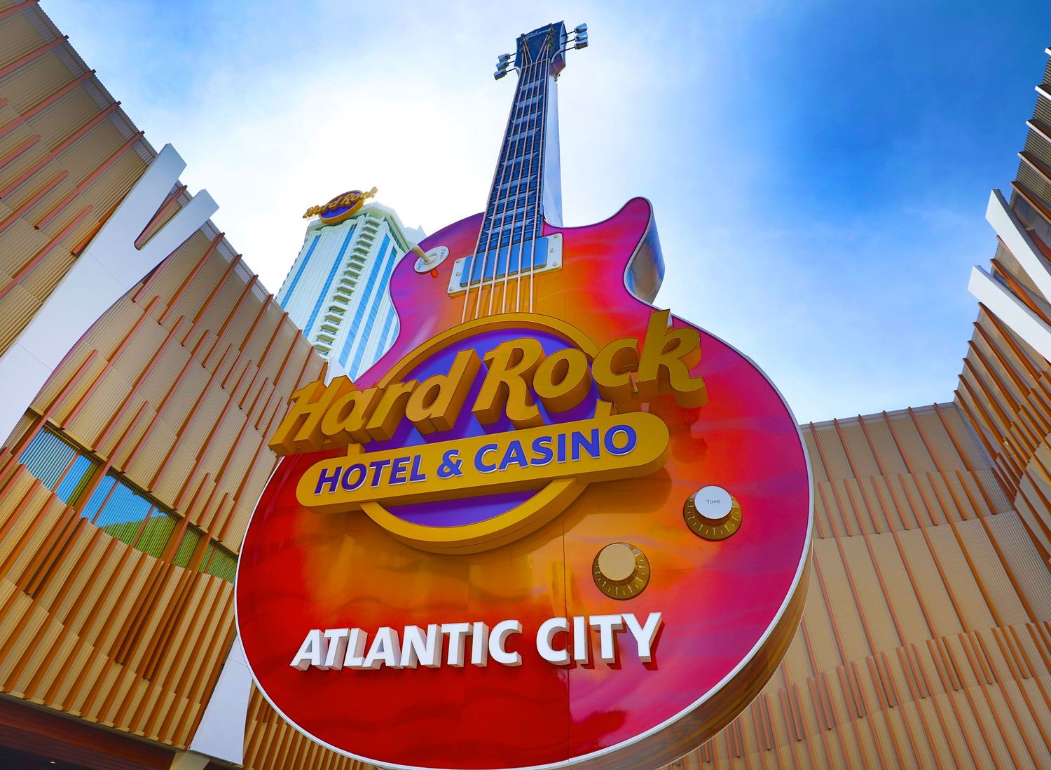 Hard Rock Hotel and Casino Atlantic City guitar sign viewed from below against blue sky.