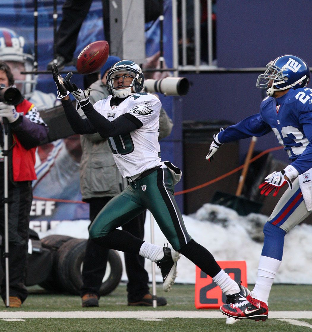 Philadelphia Eagles player diving for a tackle against New York Giants during NFL game.