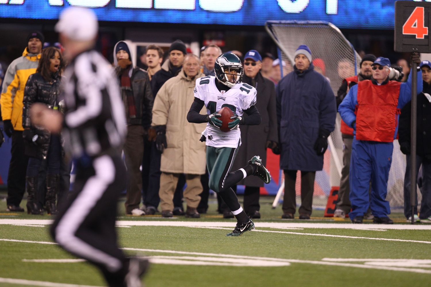 Football players and officials on the sideline during an NFL game.
