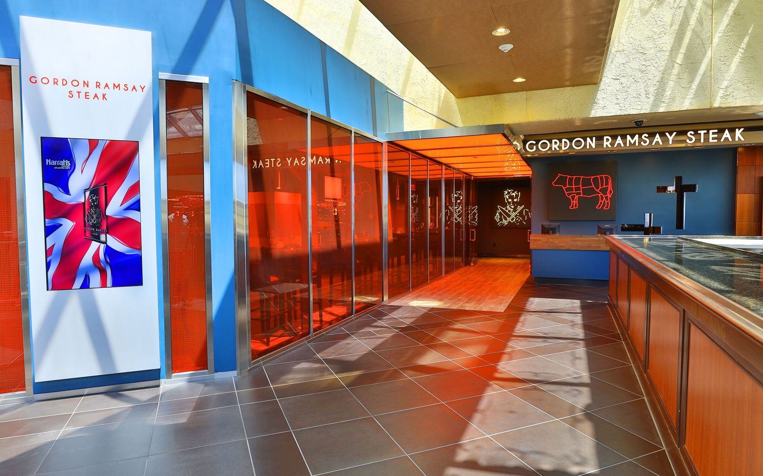 Modern shopping mall corridor with blue walls and bright lighting design.