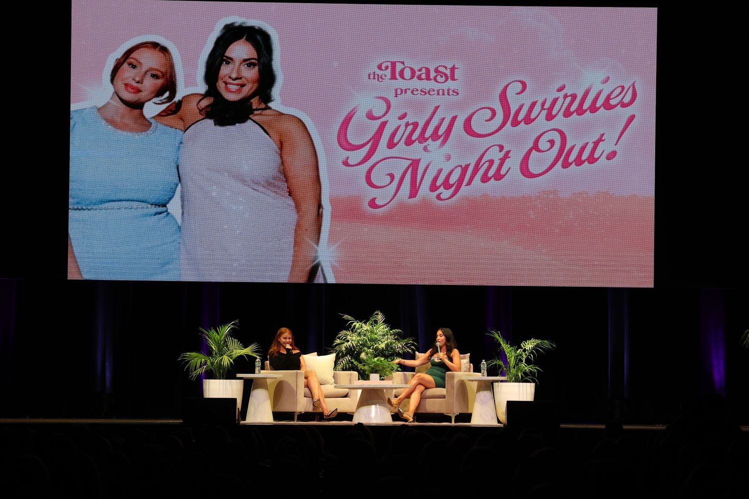 Pink-tinted stage setup for an entertainment or speaking event.