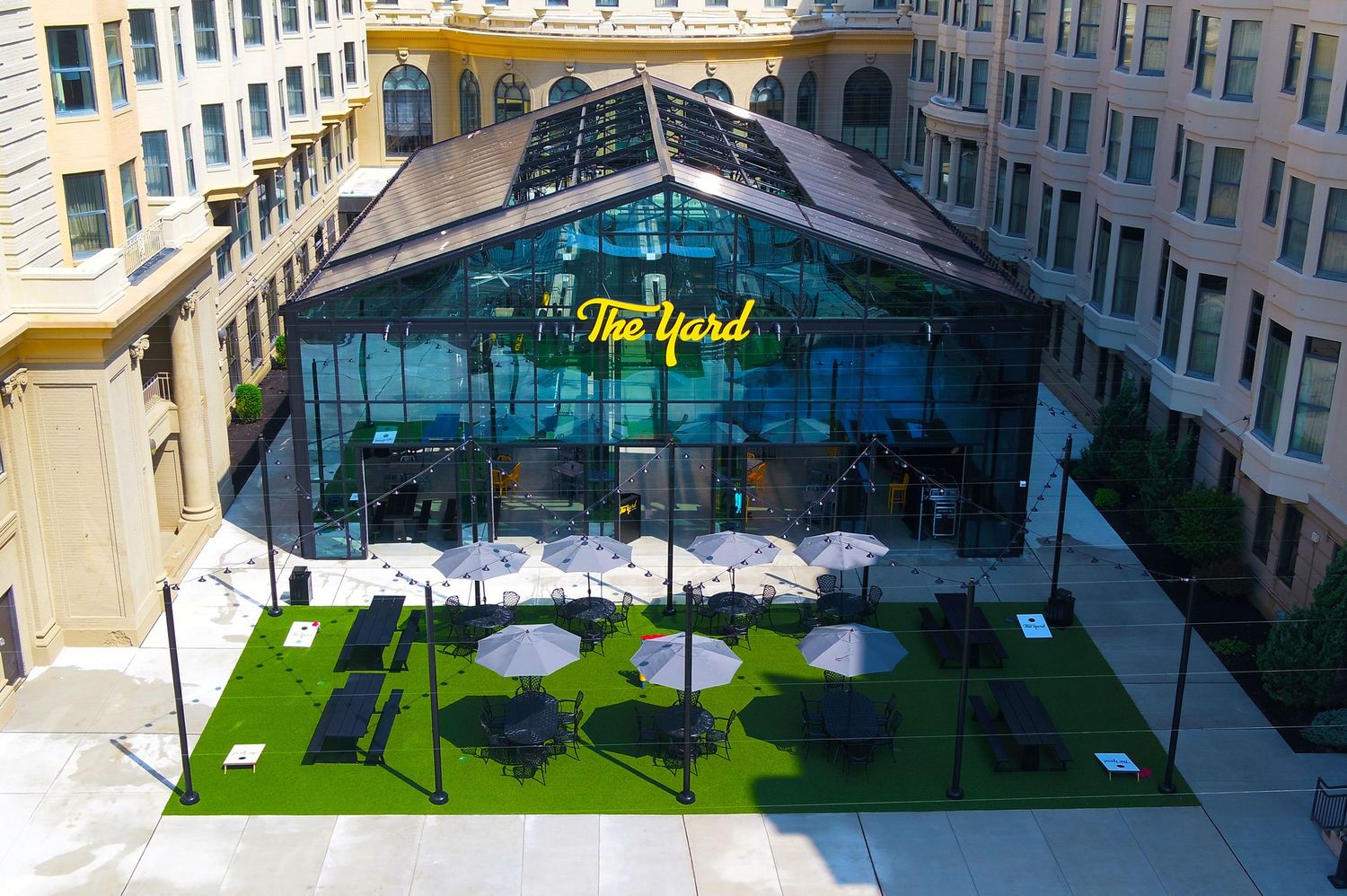 Modern courtyard space with glass ceiling and green turf installations.