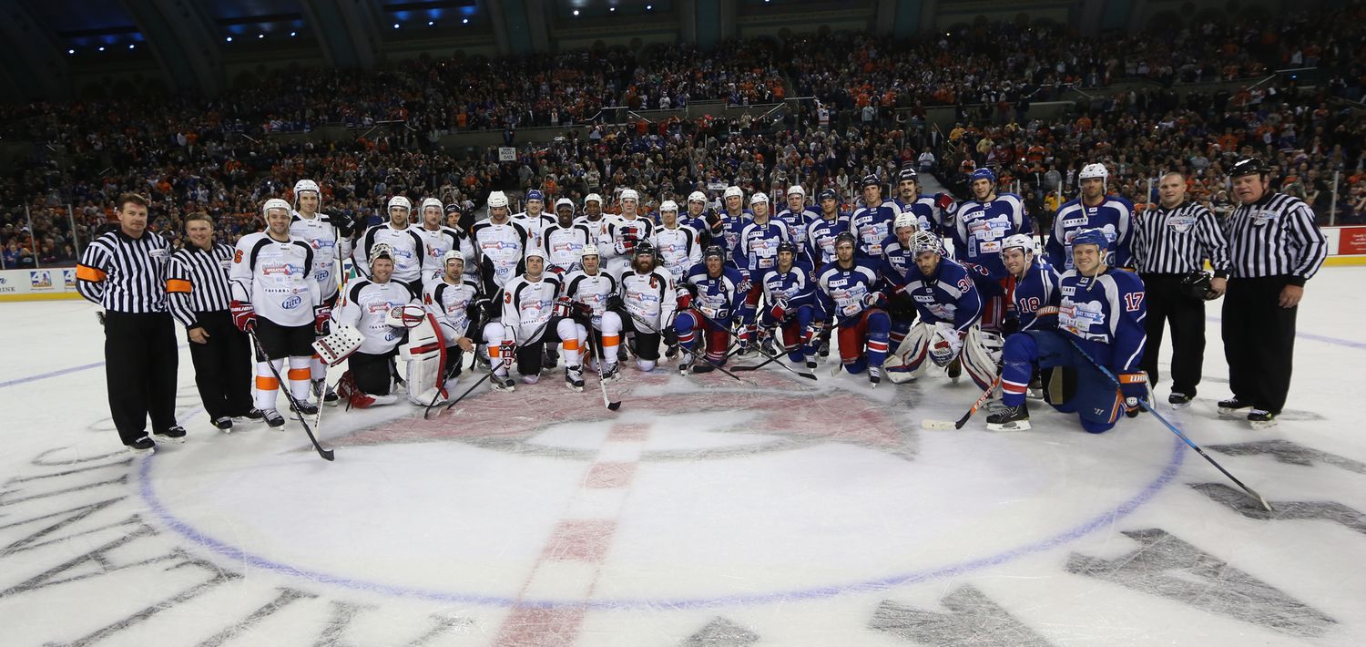 Hockey players line up along the boards during a game ceremony or special event.