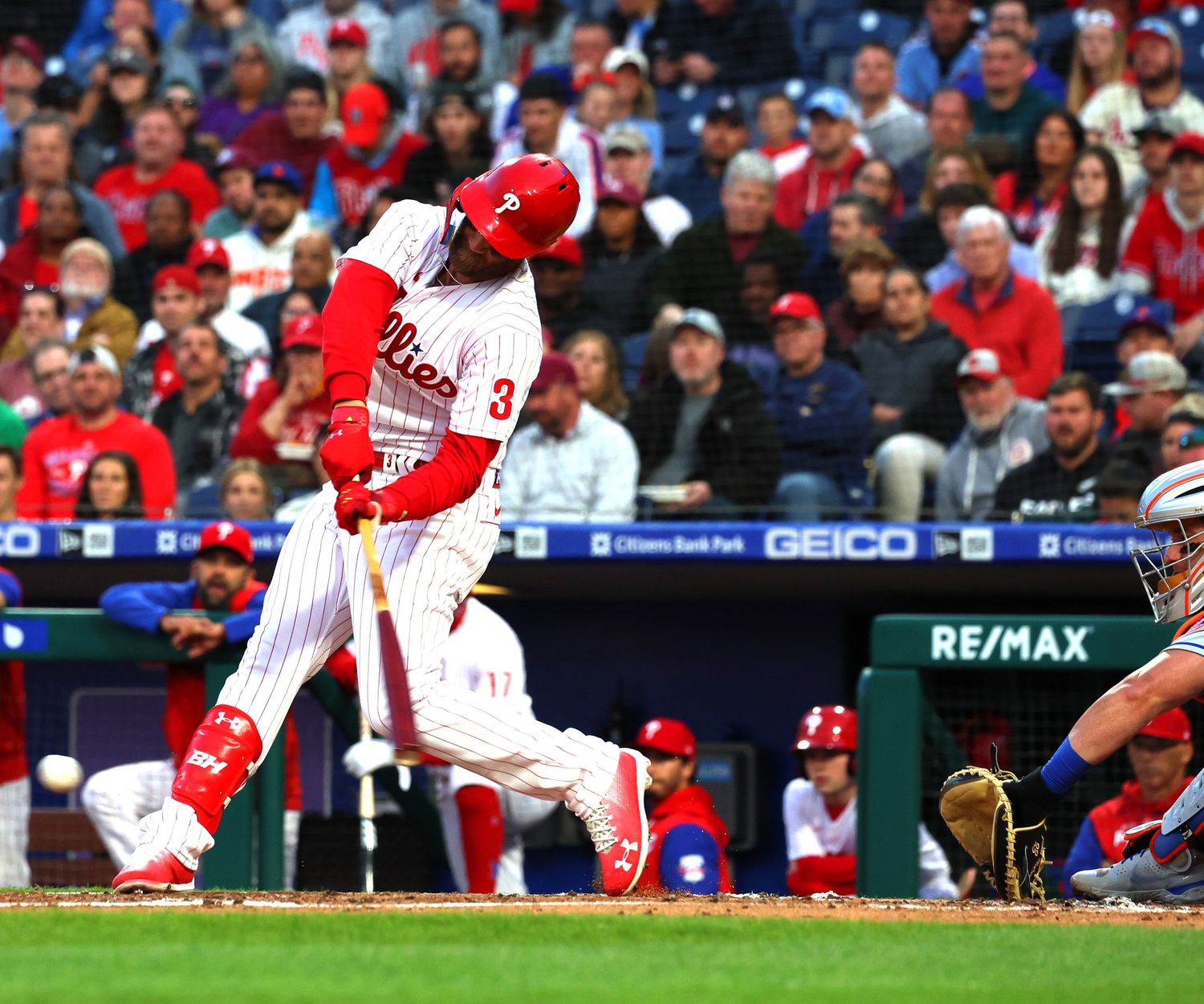 Baseball players in red uniforms making plays during a professional game.