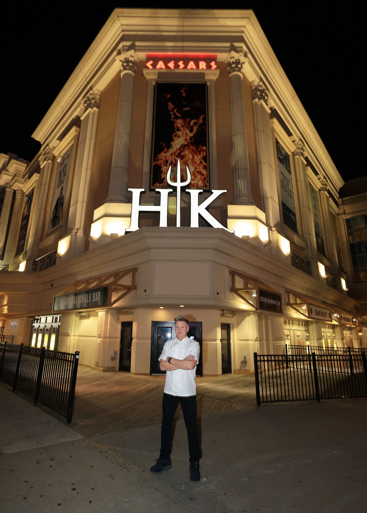 Illuminated exterior of an elegant building with white columns and architectural details at night.