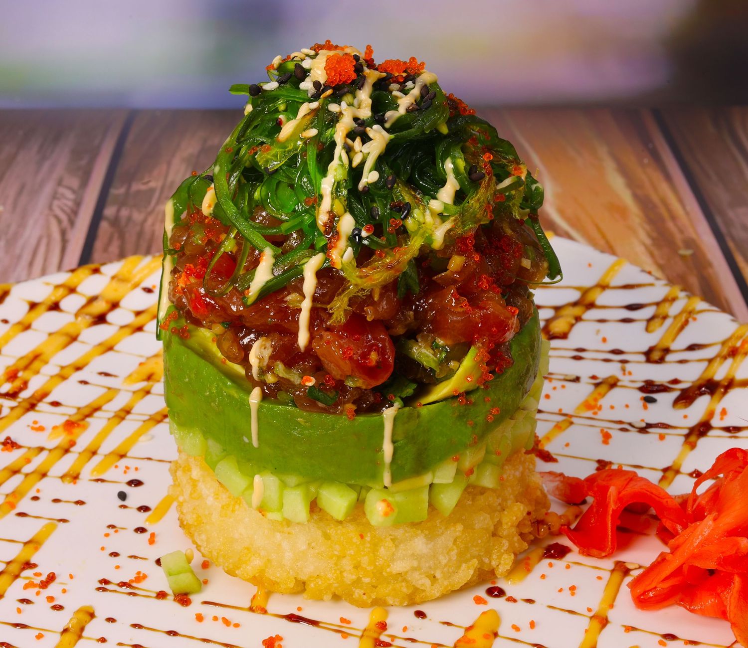 Colorful tostada appetizer with fresh toppings and decorative sauce plating.