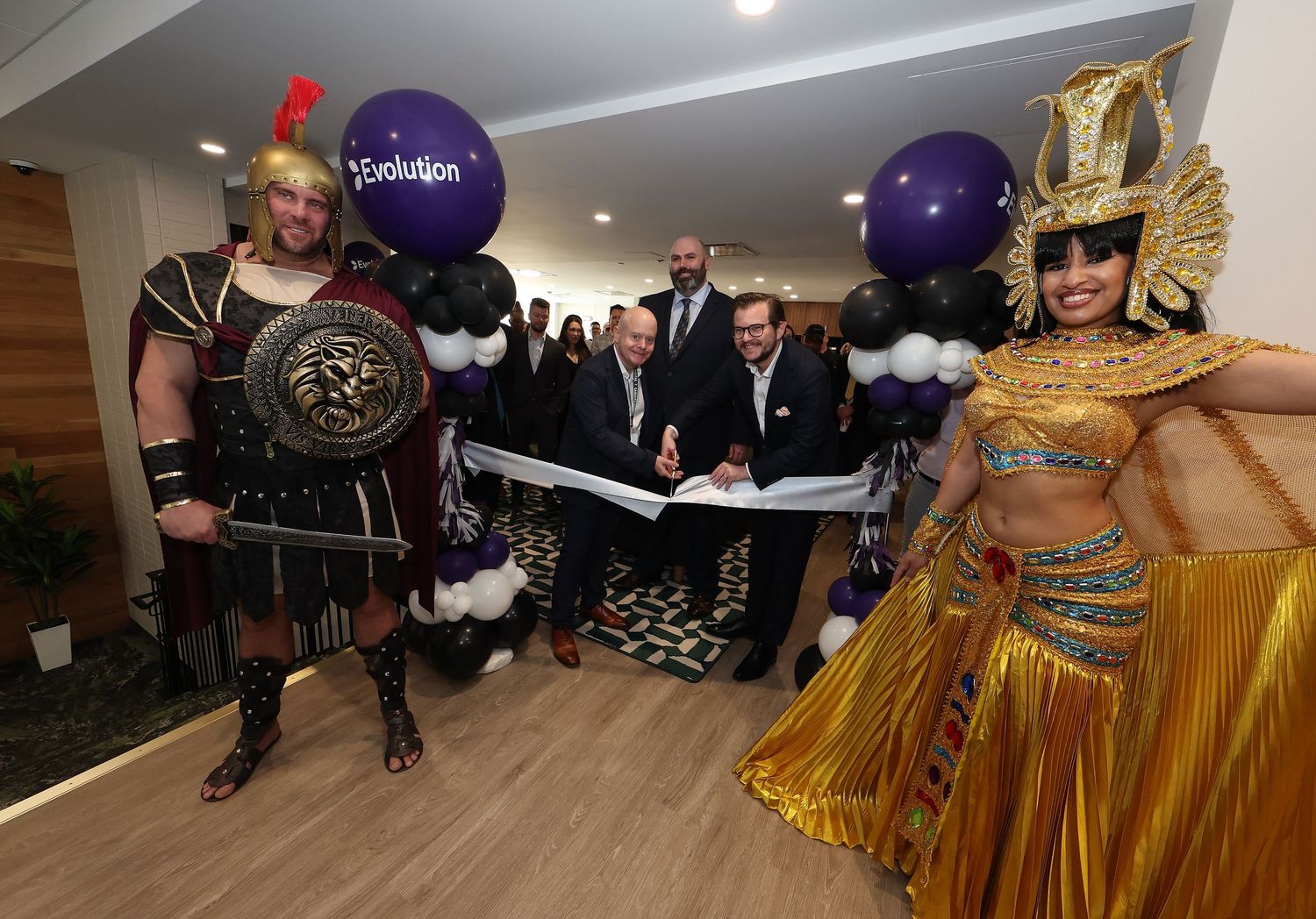Festive party scene with purple and gold decorations in an indoor venue.