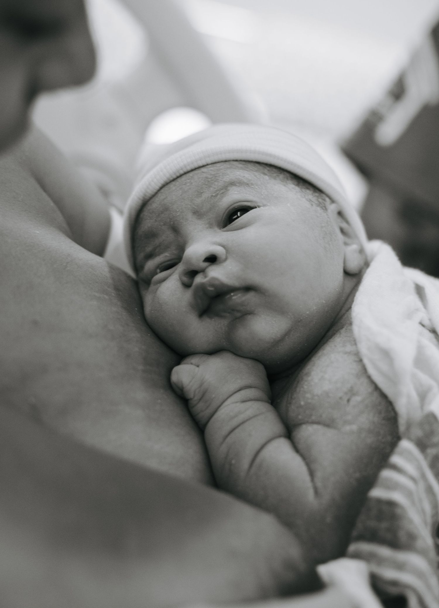 Close-up black and white portrait of newborn baby resting peacefully.